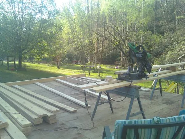 Miter saw and framing lumber on a deck under construction in Burlington